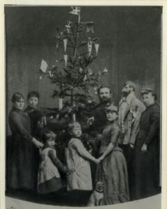 Historisk fotografi af familie rundt om juletræ i 1880erne